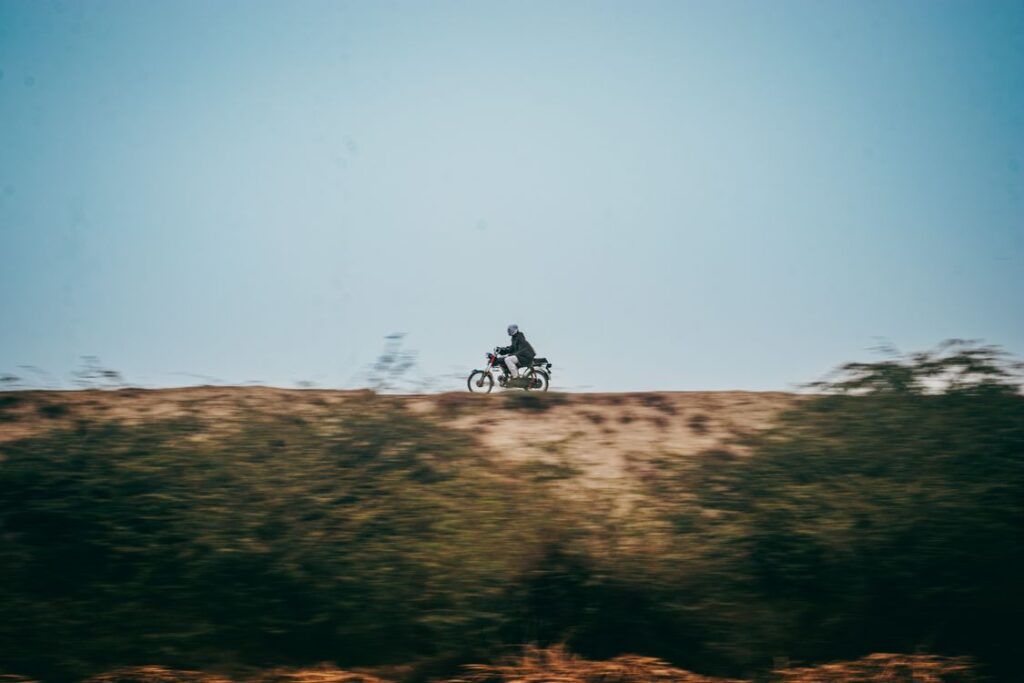 Motociclista pilotando em estrada aberta sob céu azul
