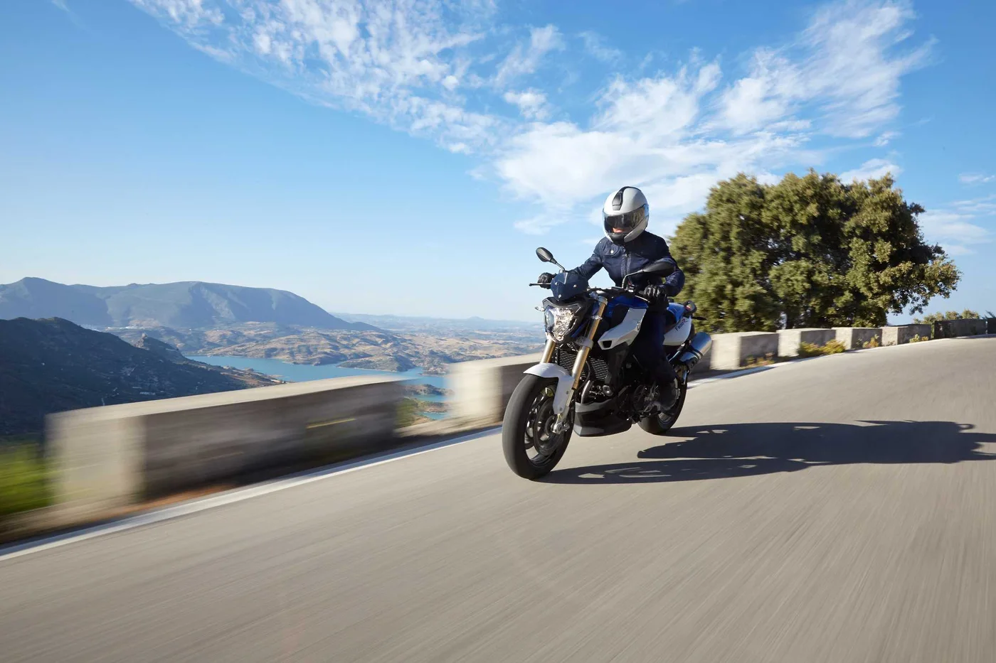 Piloto conduzindo a naked BMW F 800 R em estrada panorâmica