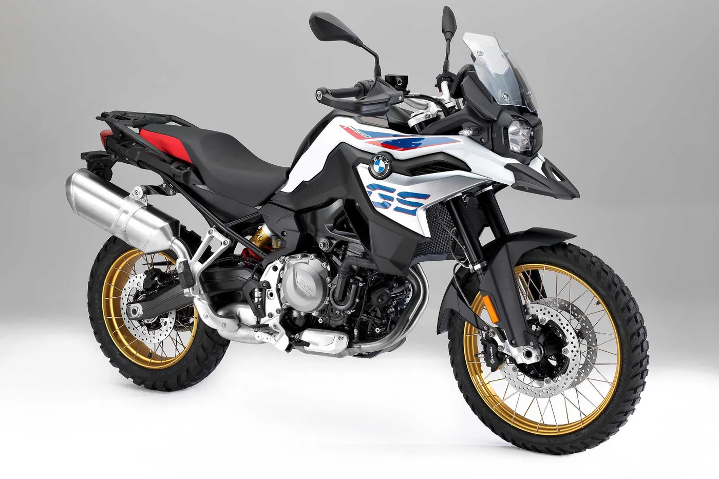 BMW F 850 GS branca com rodas de raios dourados, em estúdio