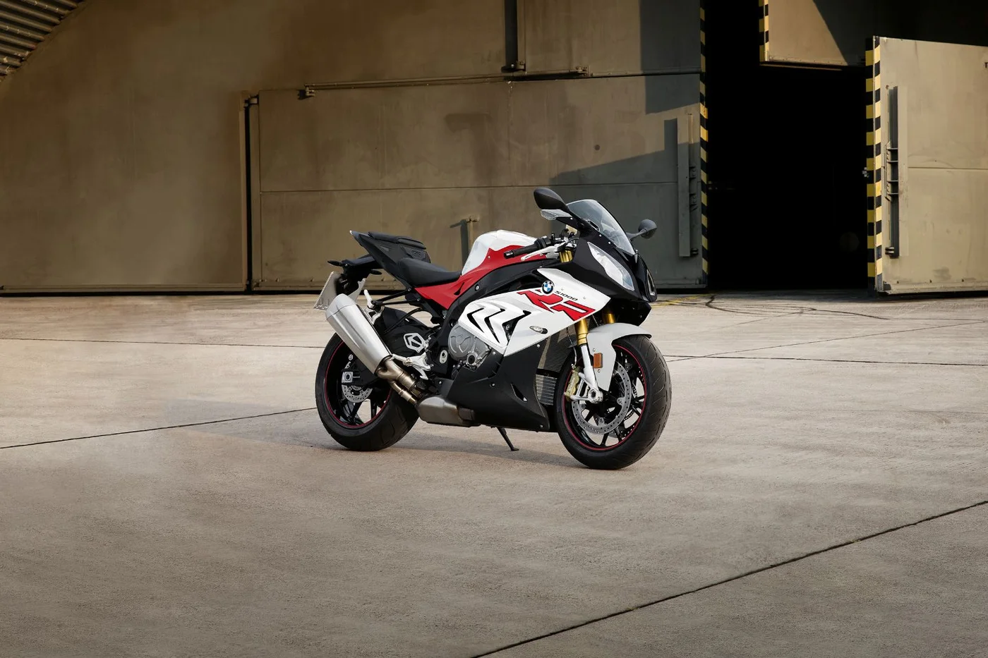 BMW S 1000 RR superesportiva vermelha, branca e preta em galpão